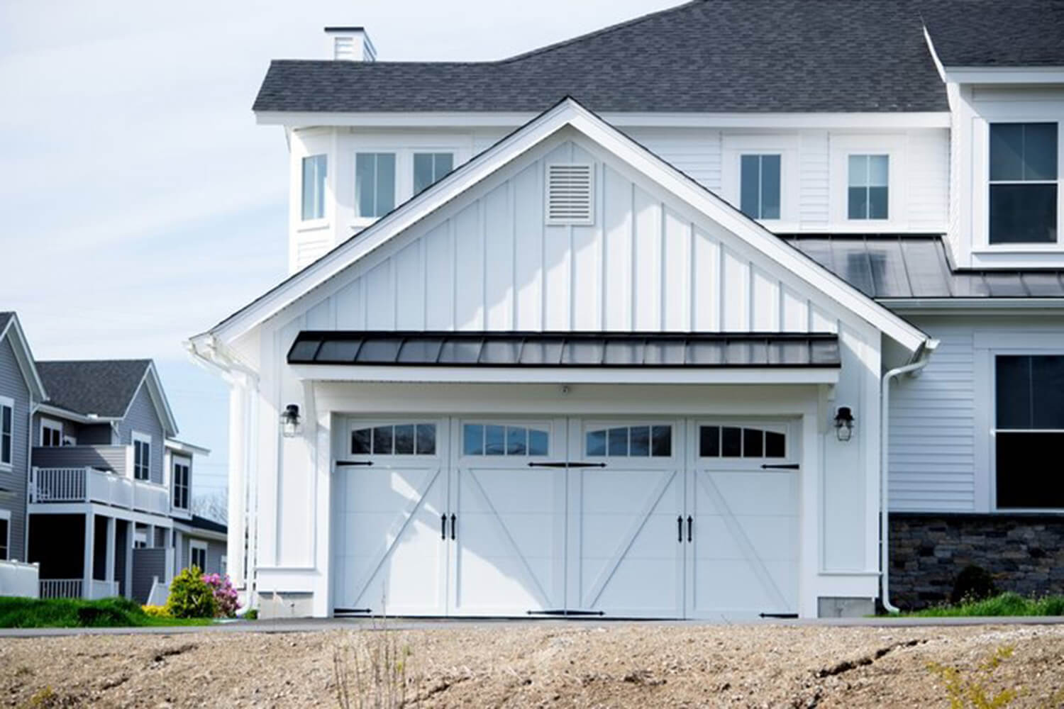 A white home exterior with board-and-batten siding and black trim details, representing one of the best exterior paint colors for Boynton Beach homes.