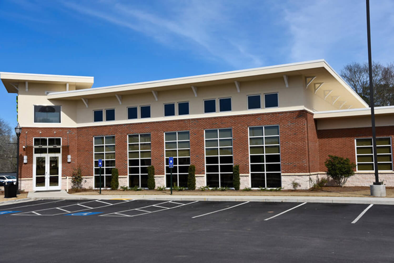 A well-maintained commercial building exterior with a parking lot, illustrating the value of knowing how to tell when commercial property needs painting.